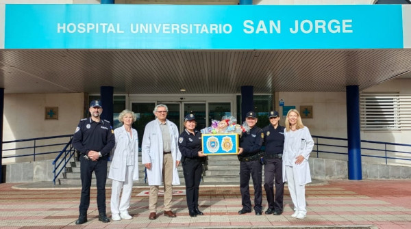 Agentes de Policía Local y Policía Nacional de Huesca han visitado a los niños del Hospital San Jorge para llevarles sus primeros regalos antes de la llegada de los Reyes Magos